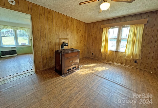 spare room with wood walls, hardwood / wood-style floors, and plenty of natural light