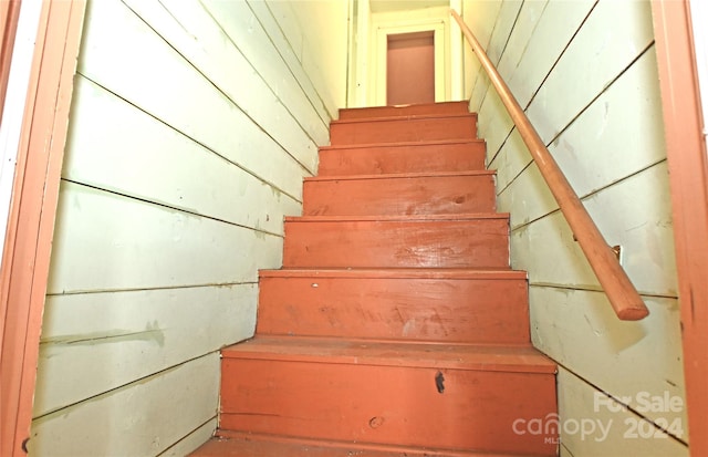 staircase with wood walls