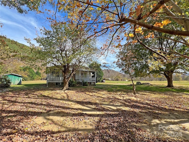 view of yard with covered porch and a mountain view