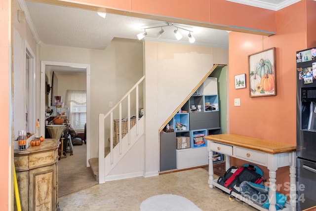 stairs featuring a textured ceiling and crown molding