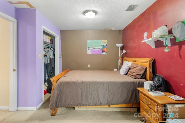 bedroom with light colored carpet, a textured ceiling, and a closet