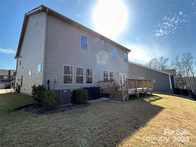 back of property with a yard, a wooden deck, and central air condition unit