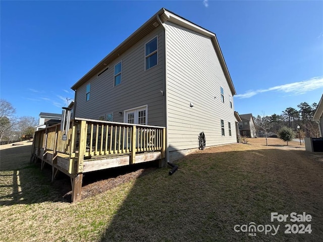 back of house featuring a yard and a deck