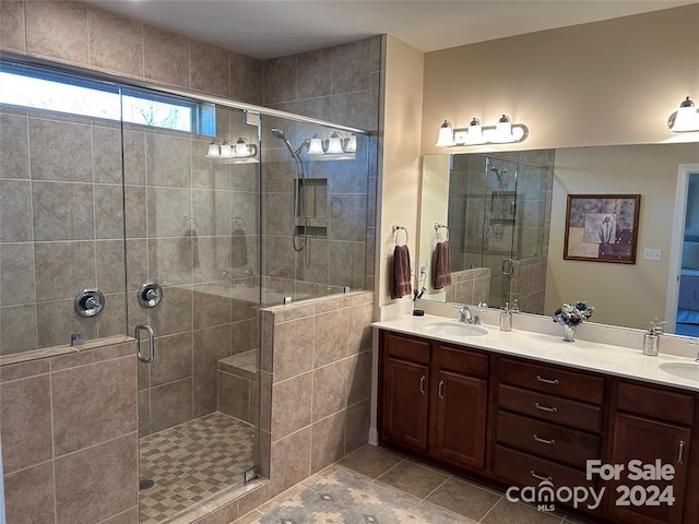 bathroom with tile patterned flooring, vanity, and walk in shower