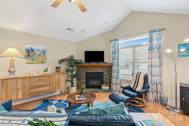 living room featuring a fireplace, light hardwood / wood-style flooring, ceiling fan, and vaulted ceiling