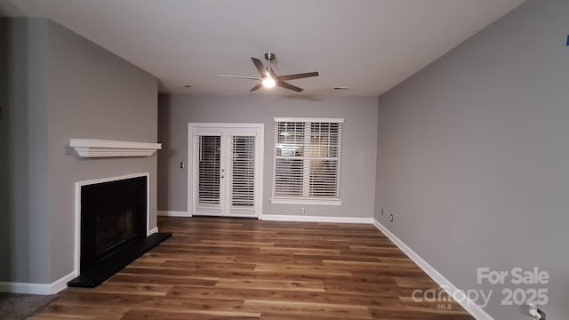 unfurnished living room featuring ceiling fan and dark hardwood / wood-style flooring