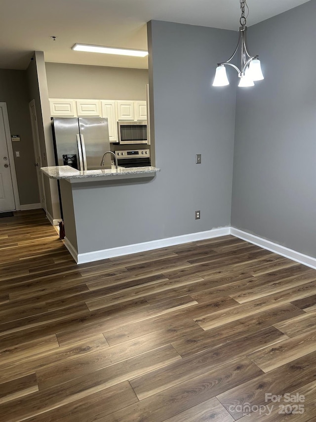 kitchen featuring white cabinetry, pendant lighting, dark wood-type flooring, and appliances with stainless steel finishes