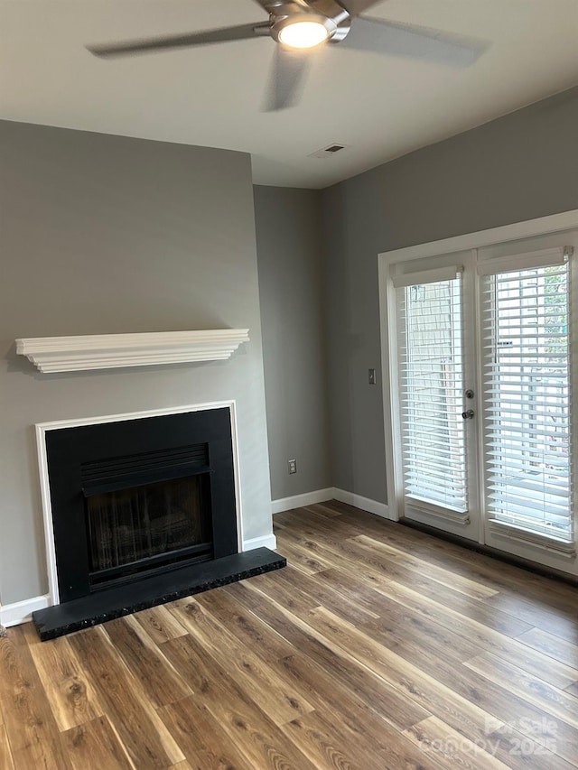 unfurnished living room with ceiling fan and hardwood / wood-style floors