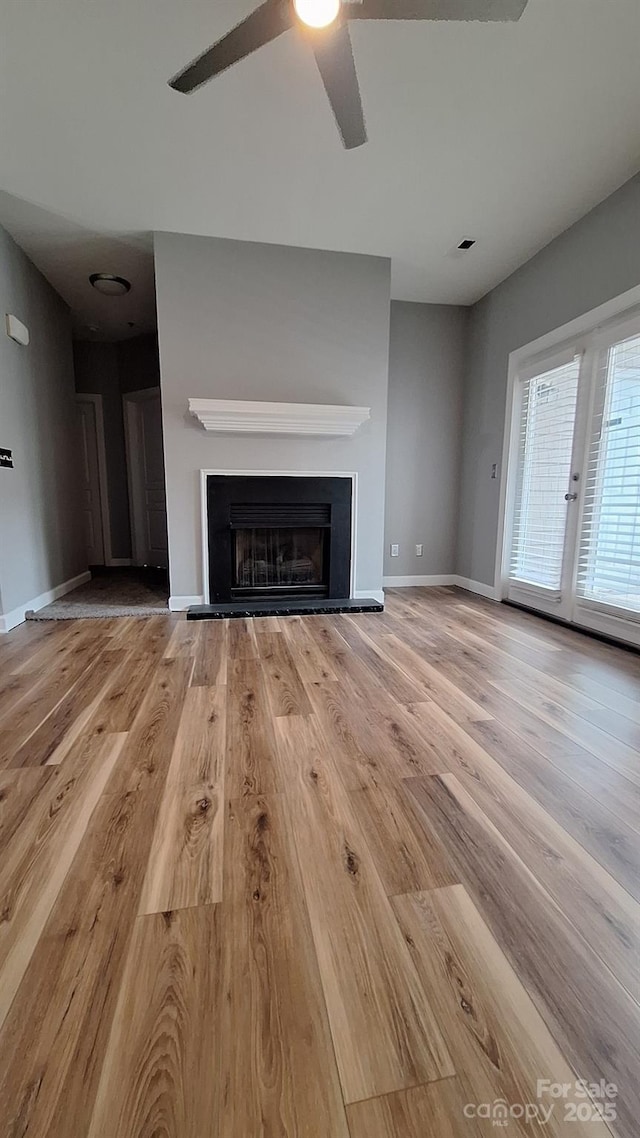 unfurnished living room with ceiling fan and light wood-type flooring