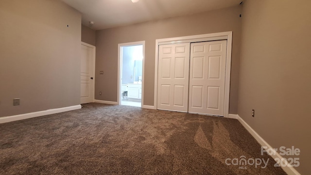 unfurnished bedroom with ensuite bathroom, carpet flooring, and a closet