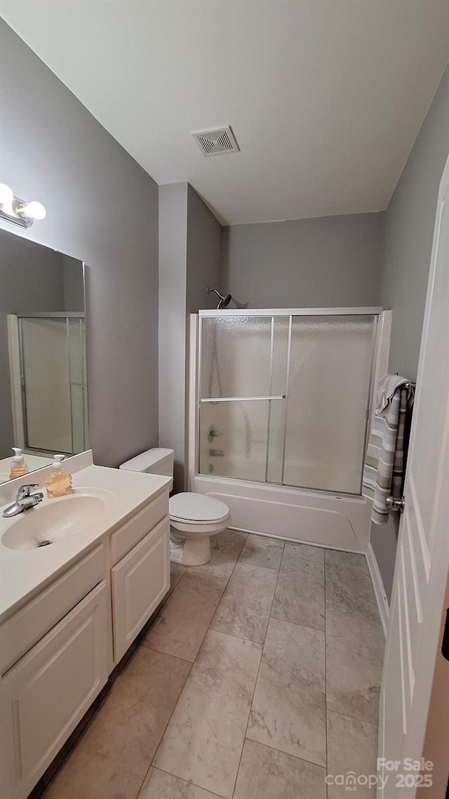 full bathroom featuring enclosed tub / shower combo, vanity, and toilet