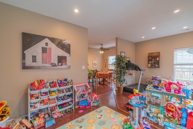 rec room with ceiling fan and dark hardwood / wood-style flooring