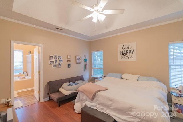 bedroom with hardwood / wood-style flooring, ceiling fan, crown molding, and connected bathroom