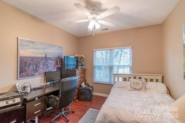 bedroom with a textured ceiling, dark hardwood / wood-style floors, and ceiling fan