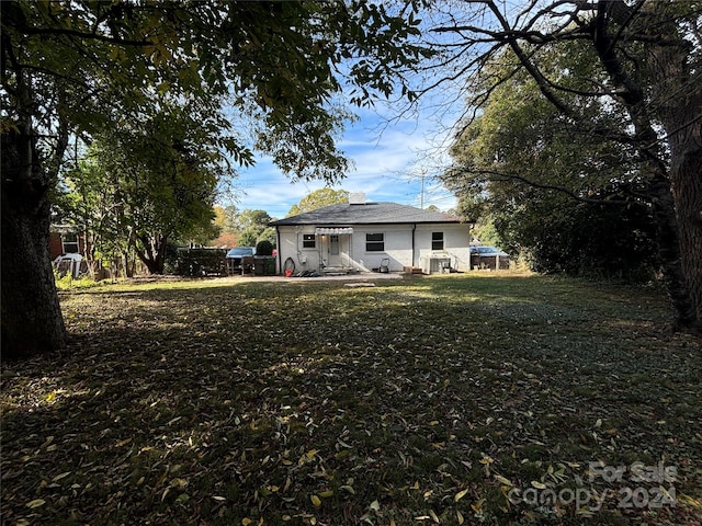 back of property with a lawn