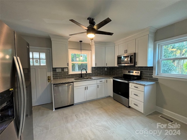 kitchen with a healthy amount of sunlight, white cabinetry, and stainless steel appliances