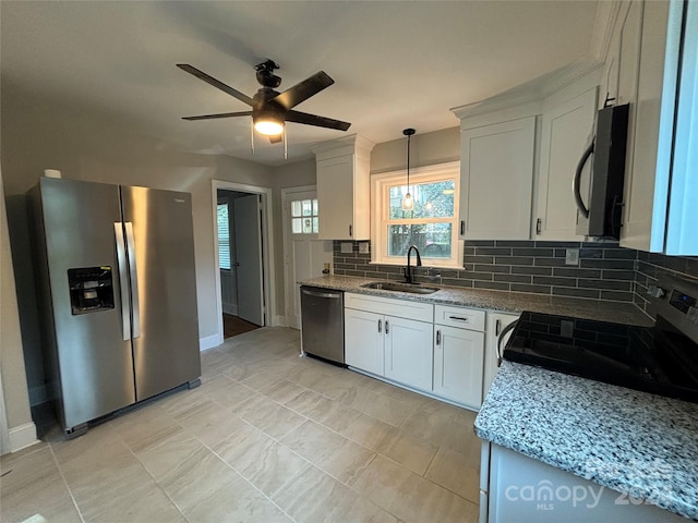 kitchen with white cabinets, stainless steel appliances, tasteful backsplash, and sink