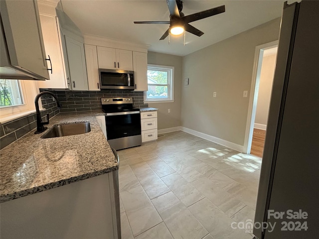 kitchen with white cabinetry, sink, stainless steel appliances, tasteful backsplash, and stone countertops