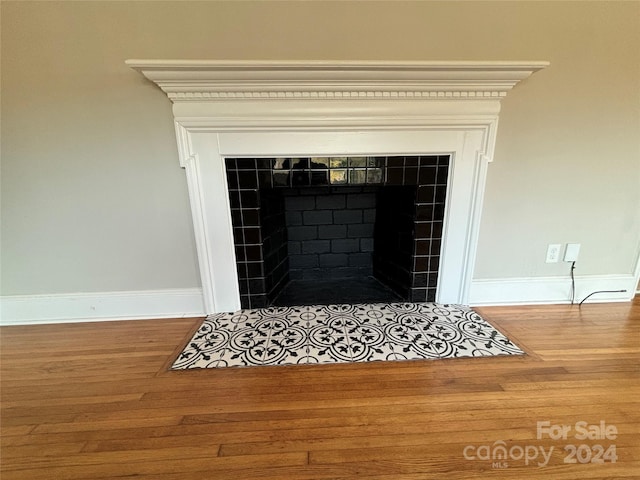 interior details featuring hardwood / wood-style floors and a tiled fireplace