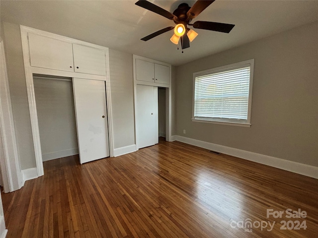 unfurnished bedroom featuring ceiling fan and dark hardwood / wood-style flooring