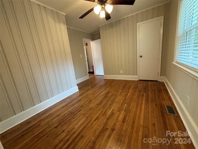 empty room with wood-type flooring, ceiling fan, and ornamental molding