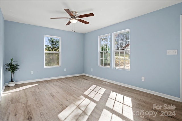 unfurnished room featuring light hardwood / wood-style floors, ceiling fan, and a healthy amount of sunlight