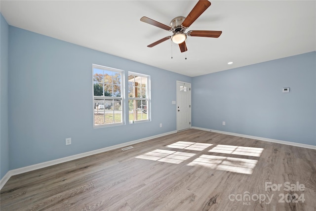 empty room with ceiling fan and light hardwood / wood-style floors