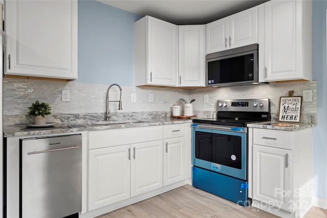 kitchen featuring white cabinets, stainless steel appliances, and light hardwood / wood-style flooring