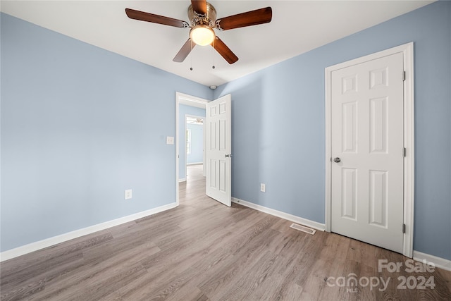 unfurnished bedroom with ceiling fan and light hardwood / wood-style flooring