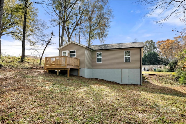 back of house featuring a lawn and a deck