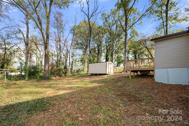 view of yard with a wooden deck and a shed