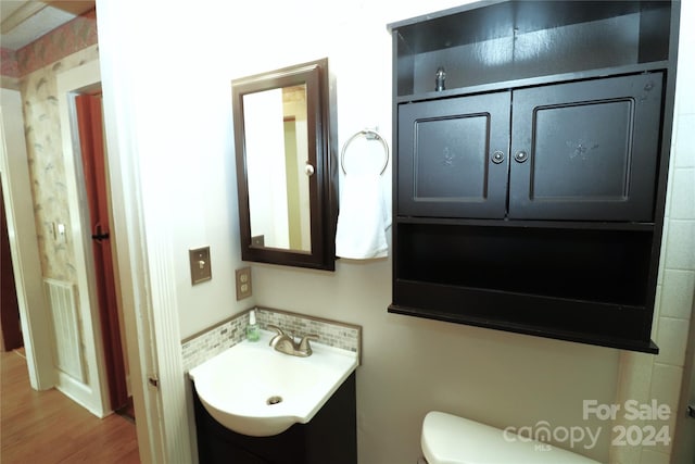 bathroom with vanity, hardwood / wood-style flooring, and toilet