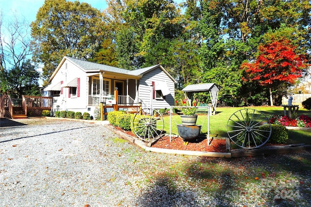 view of front of home featuring a shed, a front yard, and a porch