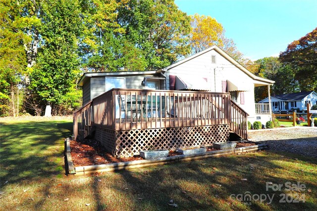 rear view of property with a yard and a deck