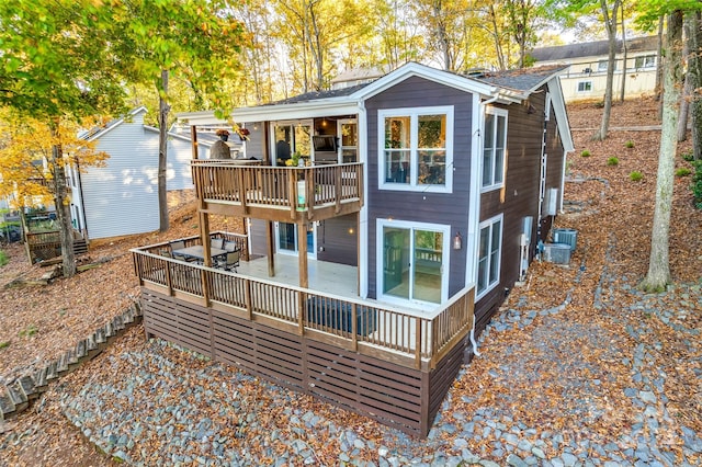 rear view of house featuring central AC and a wooden deck