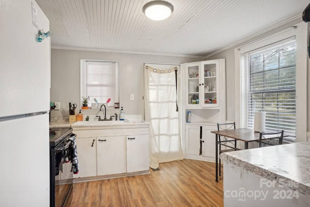 kitchen with white cabinetry, sink, light hardwood / wood-style flooring, black electric range oven, and white refrigerator