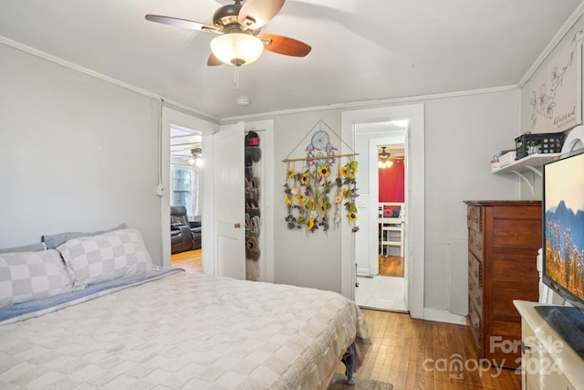 bedroom with hardwood / wood-style floors, ceiling fan, and crown molding