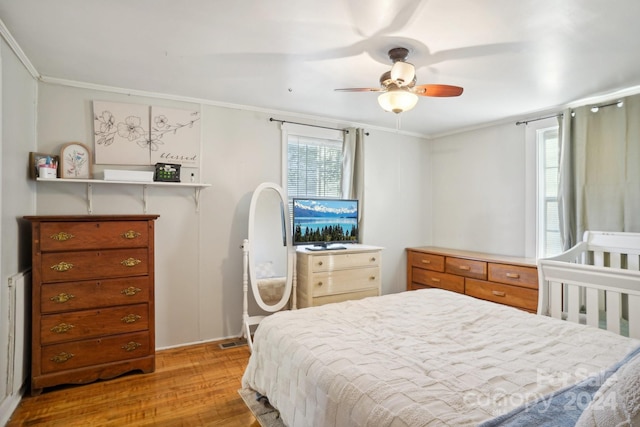 bedroom featuring light hardwood / wood-style flooring, ceiling fan, and crown molding