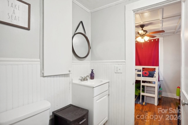 bathroom with ornamental molding, vanity, hardwood / wood-style flooring, toilet, and ceiling fan