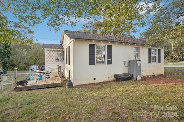 view of side of property featuring a wooden deck and a lawn