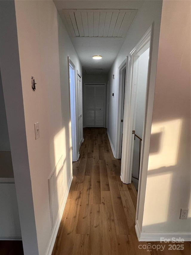 corridor with wood finished floors and visible vents