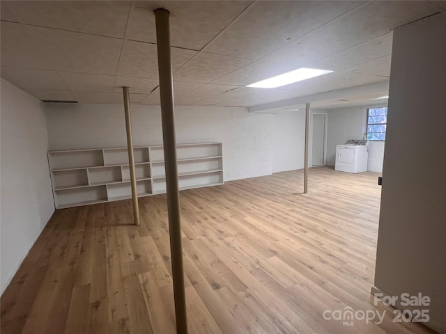 below grade area featuring separate washer and dryer and wood finished floors