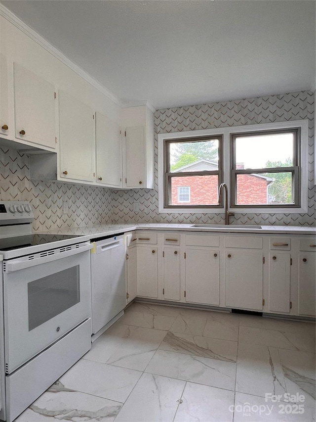 kitchen with a sink, white appliances, light countertops, plenty of natural light, and marble finish floor