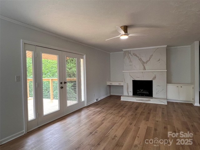 unfurnished living room with ornamental molding, french doors, and wood finished floors