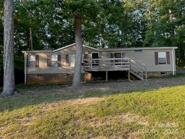 back of property with a deck and a yard