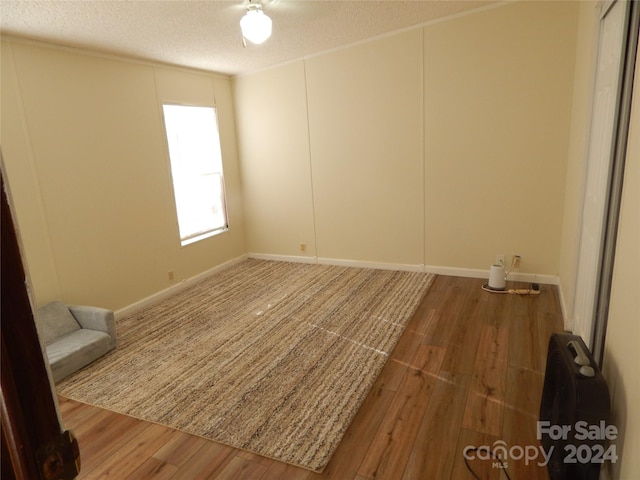 spare room with hardwood / wood-style floors and a textured ceiling