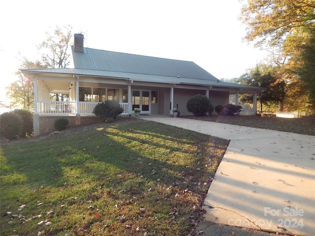 back of property with a yard and covered porch