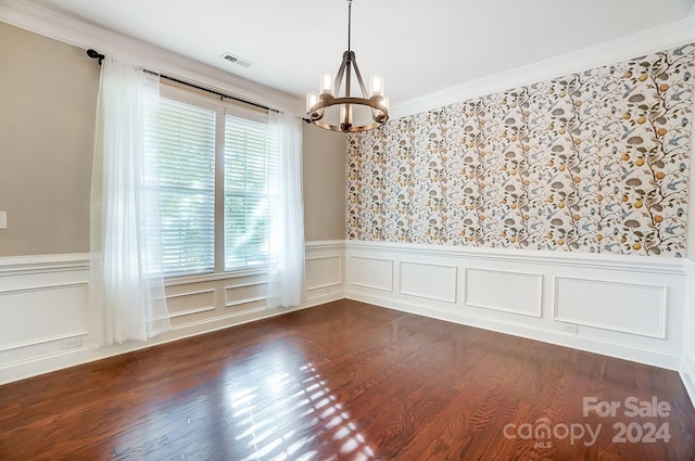 unfurnished room with dark wood-type flooring, a notable chandelier, and crown molding