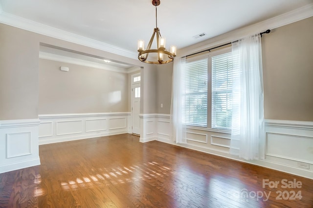 unfurnished room with dark wood-type flooring, a chandelier, and ornamental molding