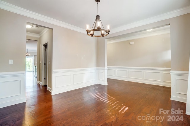 empty room featuring dark wood-type flooring, crown molding, and an inviting chandelier